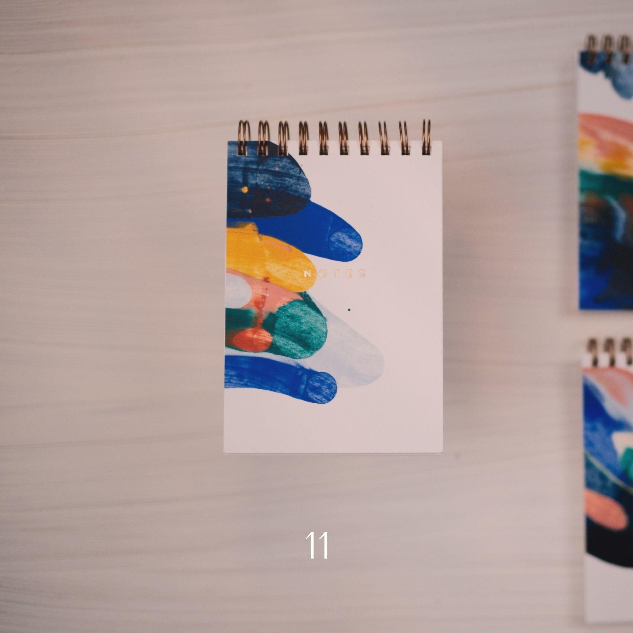 Notizblock mit abstraktem Muster auf dem Cover und dem Schriftzug Notes in gold